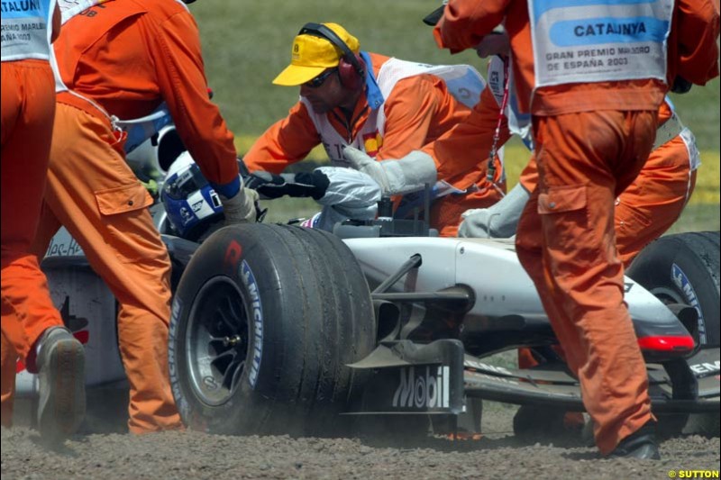 David Coulthard, McLaren, is assisted after running off into the gravel. Spanish Grand Prix. Circuit de Catalunya, Barcelona, Spain. May 4th 2003.