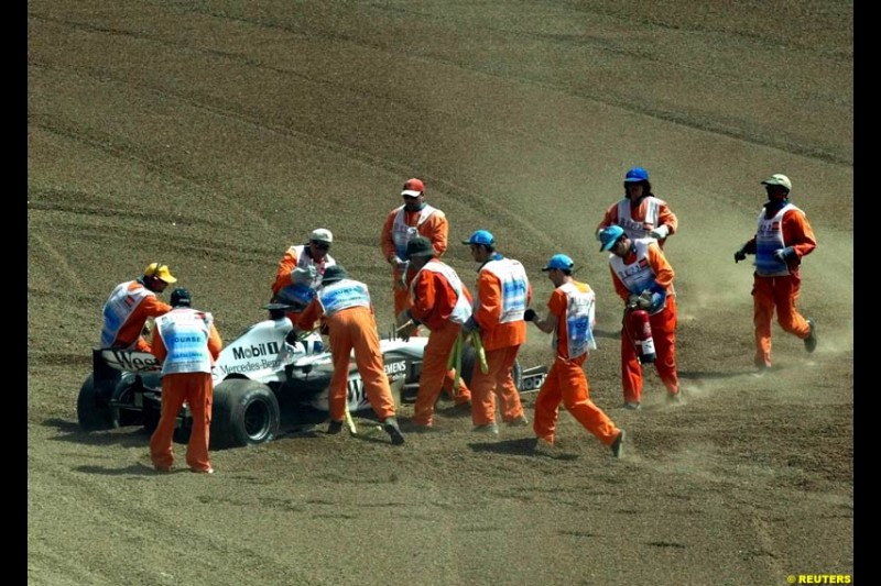 Marshals recover the car of David Coulthard, McLaren. Spanish Grand Prix. Circuit de Catalunya, Barcelona, Spain. May 4th 2003.