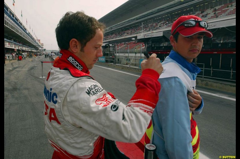 Cristiano Da Matta, Toyota, signs an autograph on the back of a pit lane marshal. Sunday, Spanish Grand Prix, Circuit de Catalunya. Barcelona, Spain, May 4th 2003.