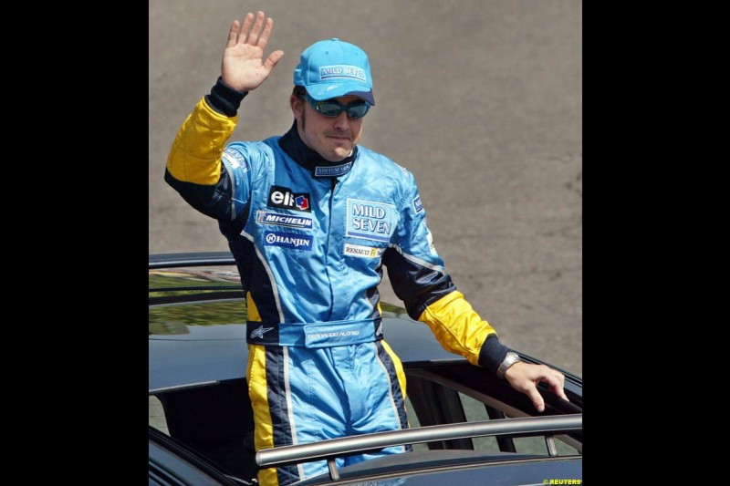 Renault's Fernando Alonso salutes the crowd after driving down Madrid's central Paseo de la Castellana during an exhibition celebrating his success so far this season. May 11th 2003.