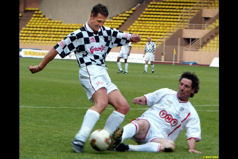 Michael Schumacher challenges french goalkeeper Jean Luc Ettori during a soccer match between the Star team for children and Formula One drivers in Monaco May 27, 2003. The event was set up for the benefit of A.M.A.D.E, a Monegasque association which helps children all around the world