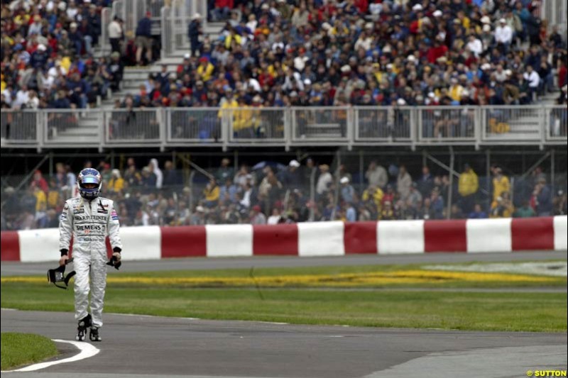 Kimi Raikkonen, McLaren, walks back to the pits after crashing out during qualifying. Canadian Grand Prix, Montreal, Saturday, June 14th 2003.