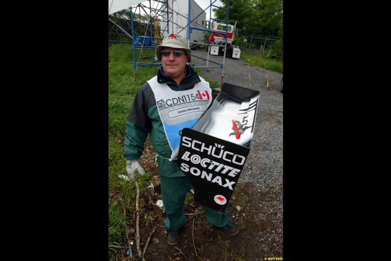 A Marshal holds the rear wing of Kimi Raikkonen, McLaren, after the driver crashed during qualifying. Canadian Grand Prix, Montreal, Saturday, June 14th 2003.