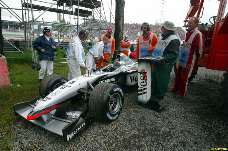 Marshals attend to the car of Kimi Raikkonen, McLaren, during qualifying. Canadian Grand Prix, Montreal, Saturday, June 14th 2003. 