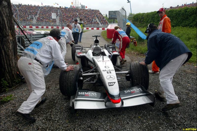 Marshals attend to the car of Kimi Raikkonen, McLaren, during qualifying. Canadian Grand Prix, Montreal, Saturday, June 14th 2003.