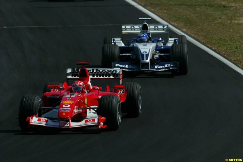 Michael Schumacher, Ferrari, followed by Juan Pablo Montoya, Williams. Hungarian Grand Prix Sunday. Hungaroring, Budapest. 24th August, 2003.