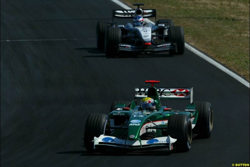 Mark Webber, Jaguar, holds off Kimi Raikkonen, McLaren. Hungarian Grand Prix Sunday. Hungaroring, Budapest. 24th August, 2003.