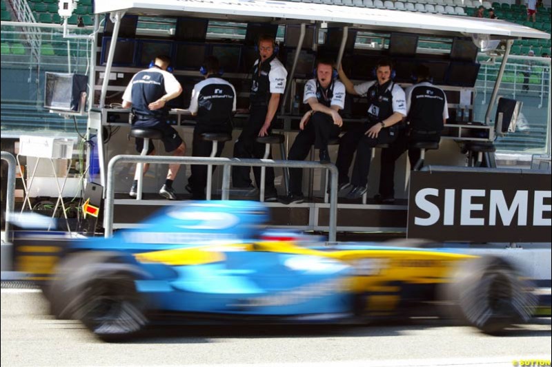 Fernando Alonso's Renault zooms past the Williams pitwall. Saturday practice for the Malaysian Grand Prix. Sepang, Kuala Lumpur, Malaysia. March 20th 2004.