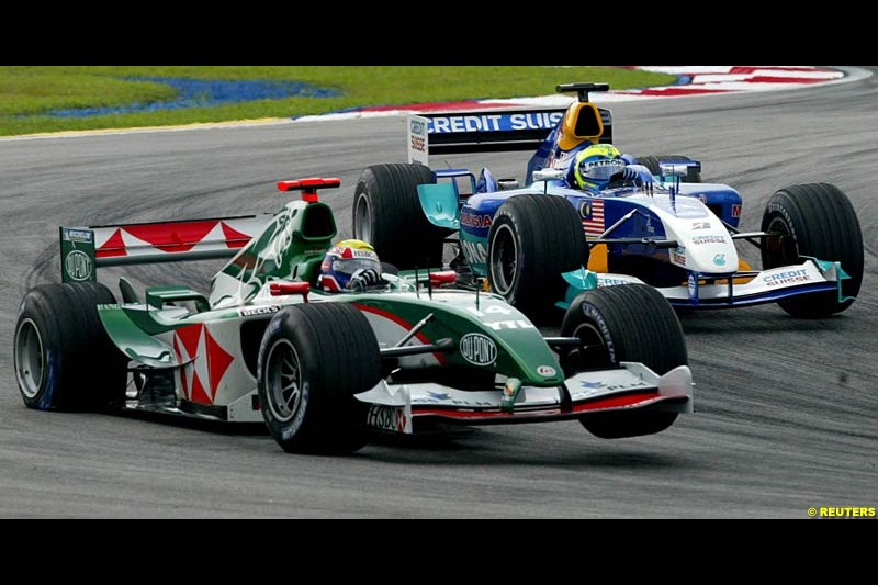 Mark Webber with a puncture on his Jaguar's rear wheel, after tangling with Ralf Schumacher. The Malaysian Grand Prix. Sepang, Kuala Lumpur, Malaysia. March 21st, 2004.