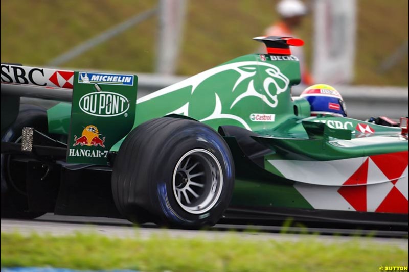 Mark Webber, Jaguar, struggles with a rear puncture. The Malaysian Grand Prix. Sepang, Kuala Lumpur, Malaysia. March 21st 2004.