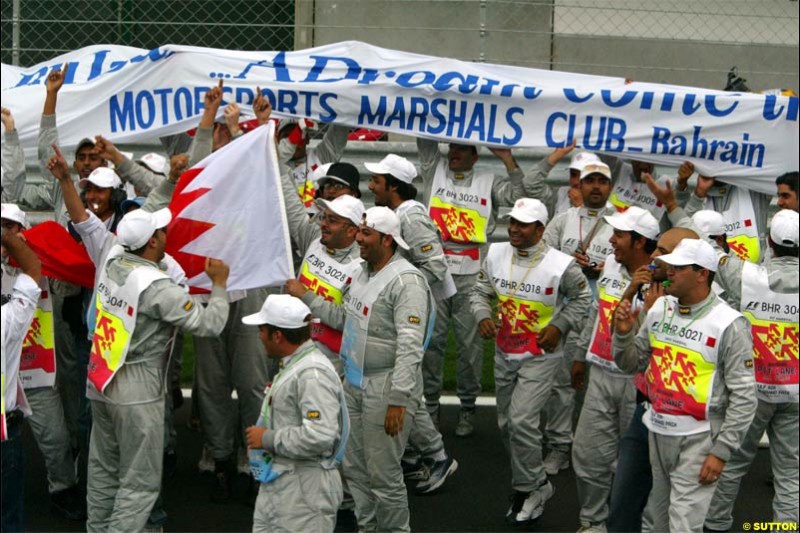 The track's marshals celebrate a job well done. The Bahrain Grand Prix. Bahrain International Circuit, April 4th 2004.