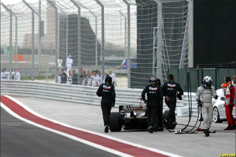 David Coulthard, McLaren, walks back to his pit garage after retiring. The Bahrain Grand Prix. Bahrain International Circuit, April 4th 2004.