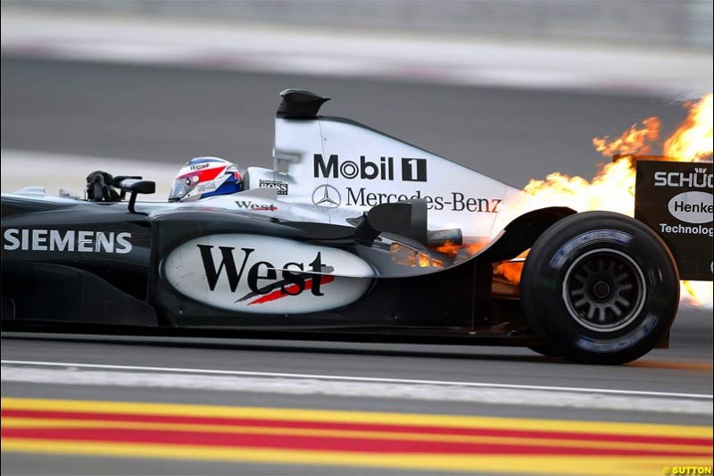 Fire erupts from the back of Kimi Raikkonen, McLaren, after a failure. The Bahrain Grand Prix. Bahrain International Circuit, April 4th 2004.