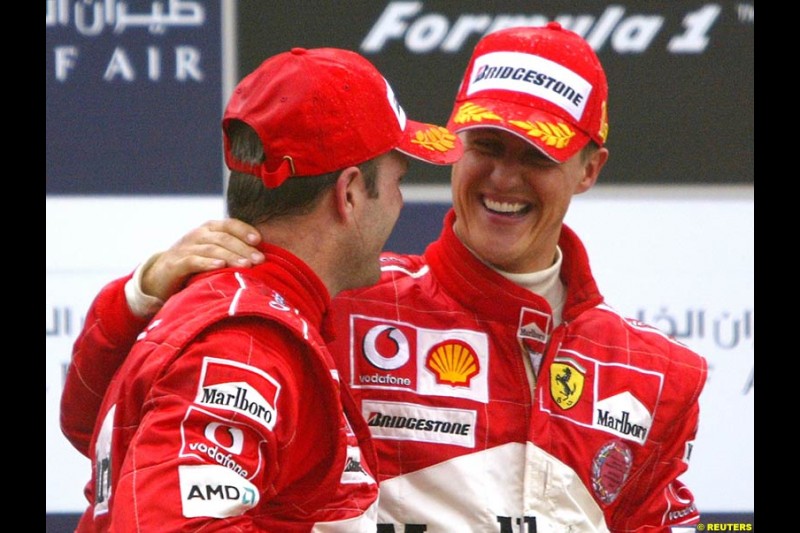 Rubens Barrichello and Michael Schumacher celebrating on the podium. The Bahrain Grand Prix. Bahrain International Circuit, April 4th 2004.