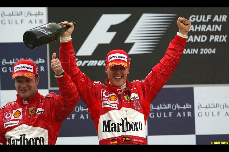 Rubens Barrichello and Michael Schumacher celebrating on the podium. The Bahrain Grand Prix. Bahrain International Circuit, April 4th 2004.