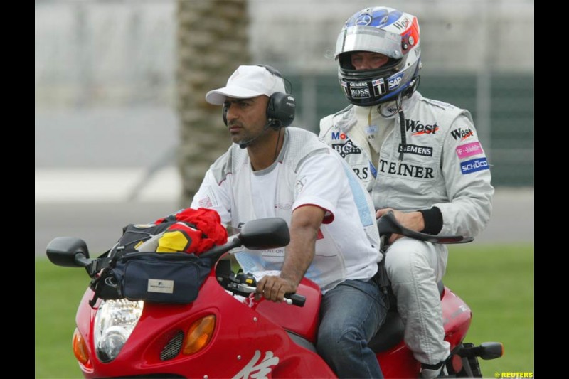 Kimi Raikkonen, Mclaren, on the way back to the pits after retiring. The Bahrain Grand Prix. Bahrain International Circuit, April 4th 2004.