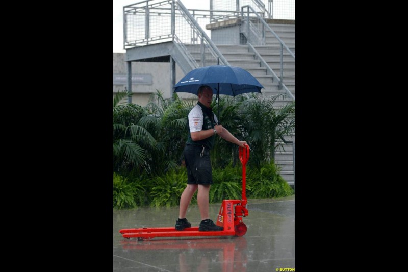 Showers catch F1 personnel at work. United States GP, Indianapolis. June 17th, 2004.