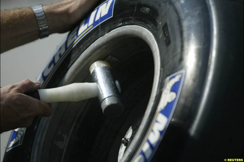 A BAR-Honda mechanic taps a weight on to a tire as teams prepare their cars for the United States Grand Prix. Indianapolis, June 17th 2004.