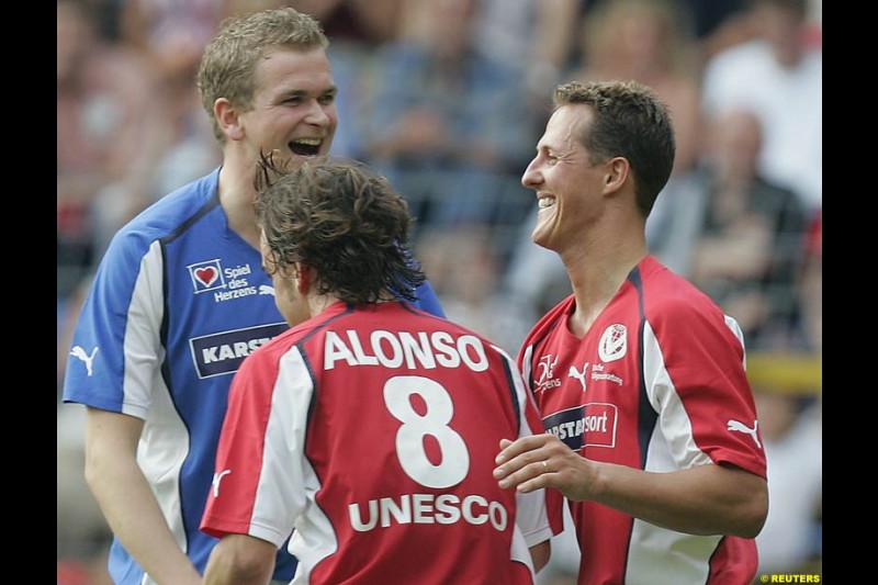 Michael Schumacher celebrates his penalty goal with Fernando Alonso during a charity soccer match in Mannheim, July 21, 2004.
