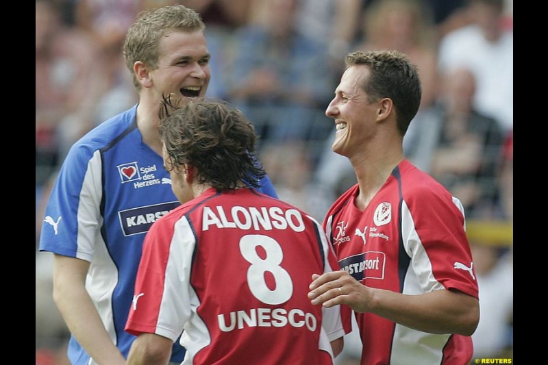 Michael Schumacher celebrates his penalty goal with Fernando Alonso during a charity soccer match in Mannheim, July 21, 2004.  