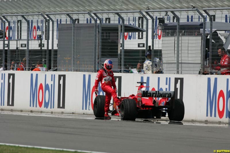 Rubens Barrichello looks at the damaged tire of his Ferrari; German GP, Sunday July 25th, 2004.