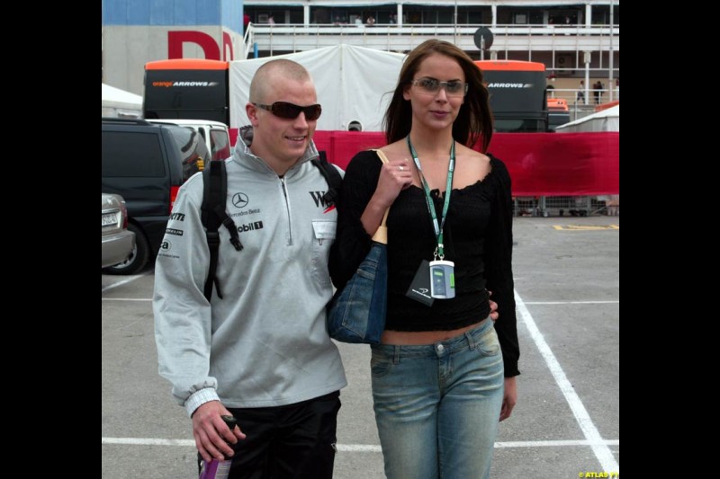 Kimi Raikkonen, sporting a new hair-do (or none, for that matter), leaves the paddock after the race with his girlfriend. Barcelona, Spain. April 28th 2002.