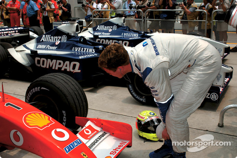 Ralf Schumacher inspecting the tires on the Ferrari