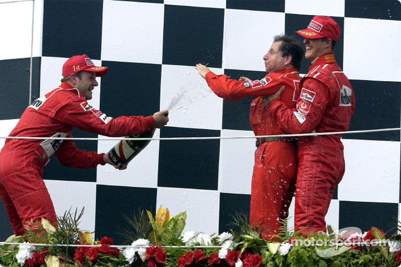 The podium: champagne for race winner Rubens Barrichello, Michael Schumacher and Jean Todt