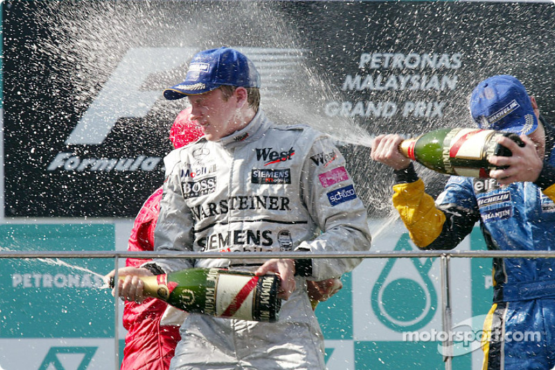 The podium: champagne for race winner Kimi Raikkonen, Rubens Barrichello and Fernando Alonso