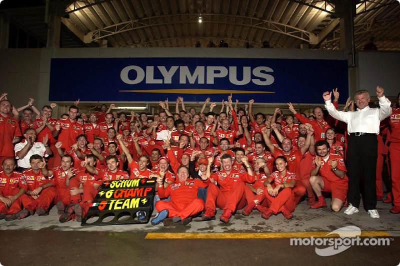 Michael Schumacher and Rubens Barrichello celebrate with Ferrari team members