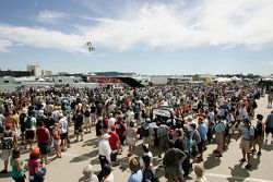 The large Friday crowd watches motorcycle jumpers as they wait for the Champ Car autograph session to begin