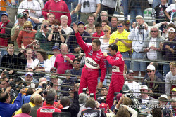 Gil de Ferran and Helio Castroneves wave to the cameras
