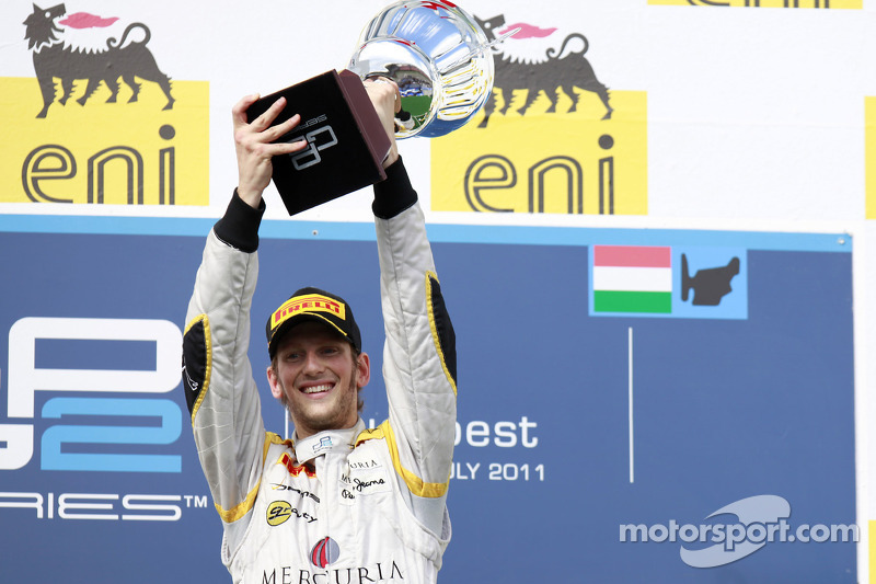 Romain Grosjean celebrates his fifth feature race win of the season on the podium