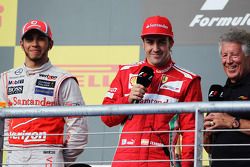 Winnaar Lewis Hamilton, McLaren met Fernando Alonso, Ferrari en Mario Andretti, op het podium