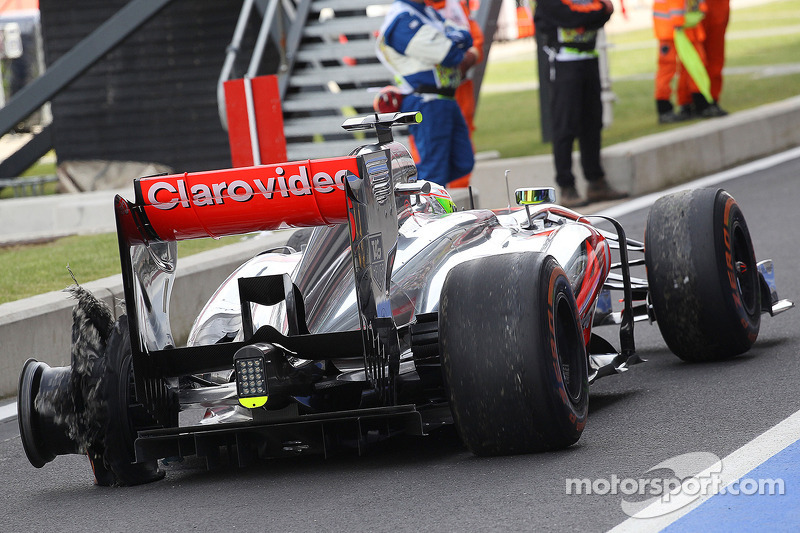 Sergio Perez, McLaren MP4-28 returns to the pits with a rear tyre puncture in the third practice ses