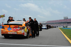 Teams push back the cars after qualifying was rained out