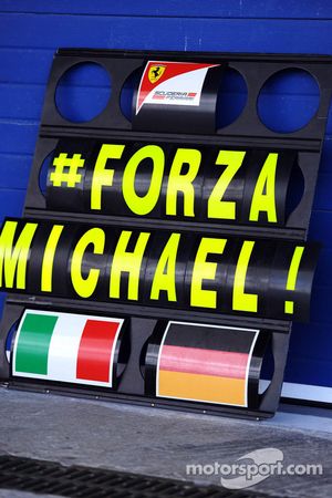 Placa de sinalização de box da Ferrari, com mensagem de apoio a Michael Schumacher