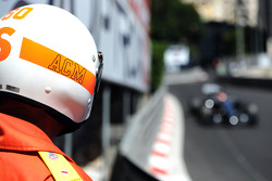 Un oficial de pista observa a Jenson Button, McLaren MP4-29