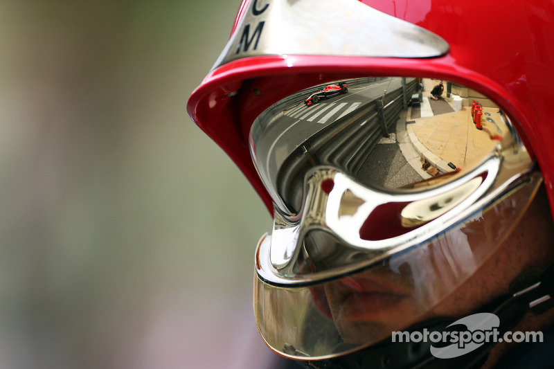 Jules Bianchi, del equipo Marussia F1 MR03, reflejado en la visera del casco de un bombero