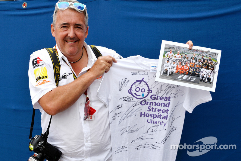 Mark Sutton of Sutton Images poses with signed memorabilia for the Great Ormond Street Hospital char