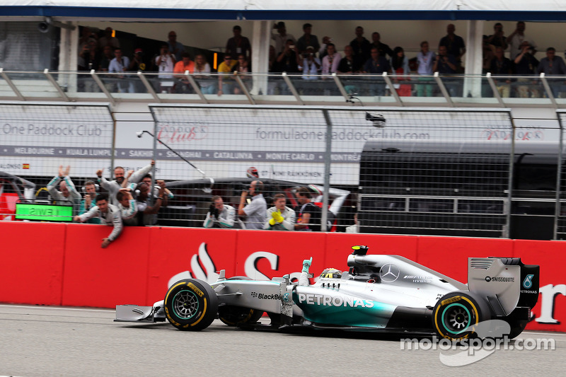 Yarış galibi Nico Rosberg, Mercedes AMG F1 W05 yarışın sonunda takımını geçiyor ve damalı bayrağı gö