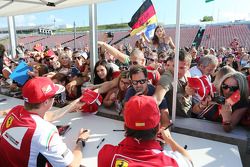 Fernando Alonso, Ferrari and team mate Kimi Raikkonen, Ferrari sign autographs for the fans