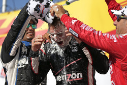 Race winner Will Power gets a face full of cream puff and champagne bath from second place Juan Pablo Montoya and third place Tony Kanaan