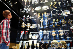 Sebastian Vettel regarde les trophées à l'usine Red Bull
