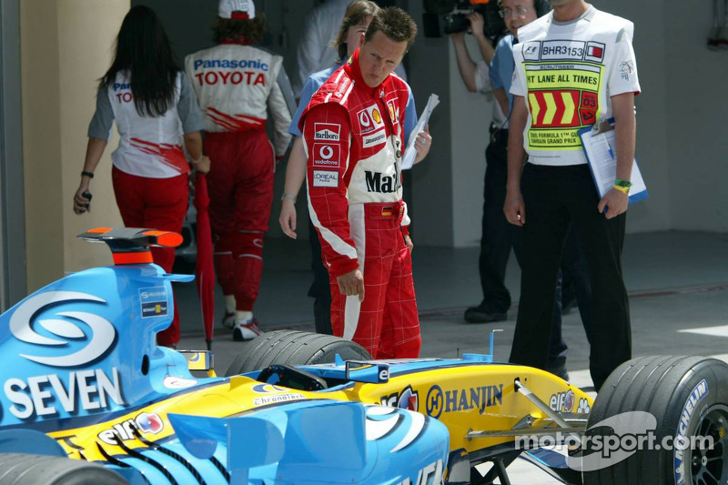 Michael Schumacher inspecciona el Renault F1 de Fernando Alonso