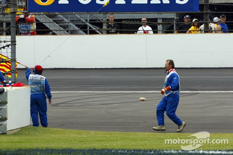 A marshall goes to recover bottles and cans of beer thrown on the track