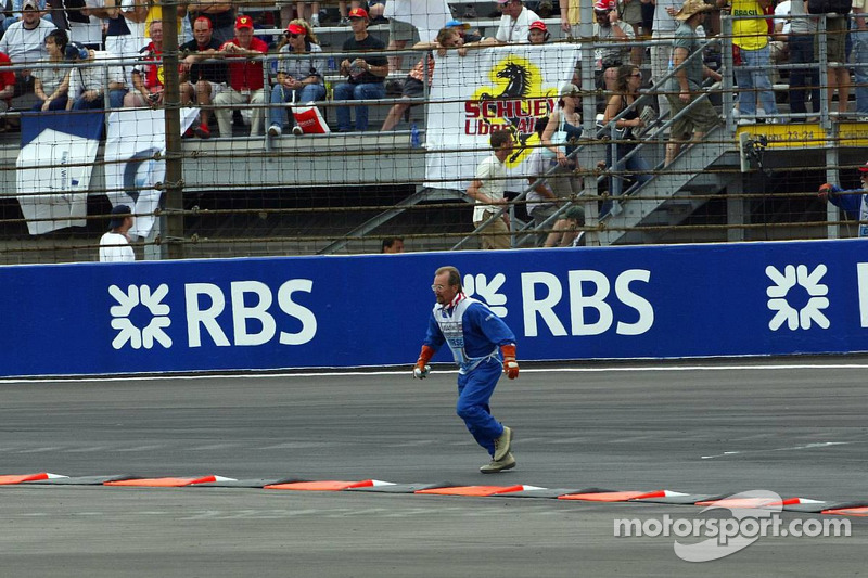 A marshall goes to recover bottles and cans of beer thrown on the track