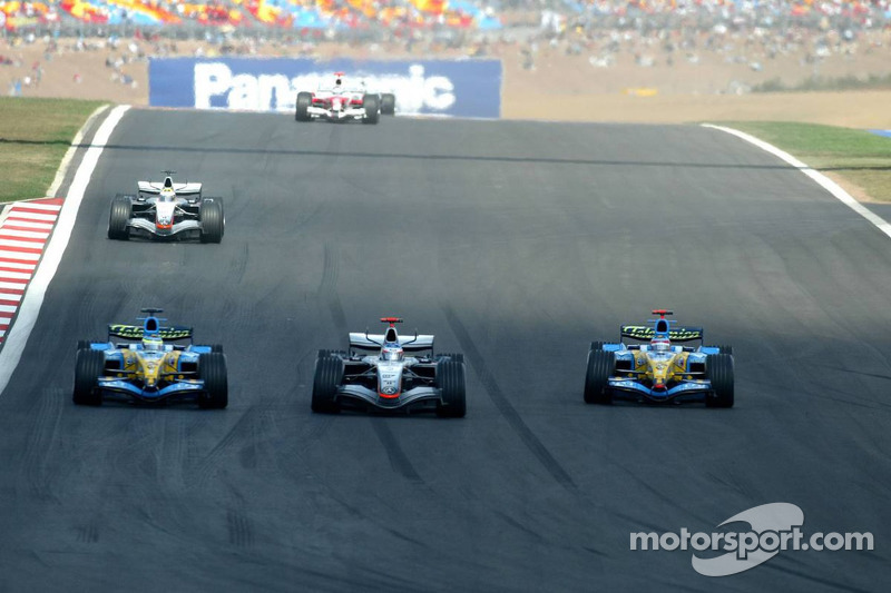 Kimi Raikkonen passes Giancarlo Fisichella while Fernando Alonso watches the action