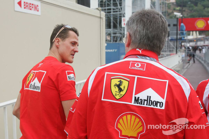 Michael Schumacher y Ross Brawn salen del edificio de los oficiales