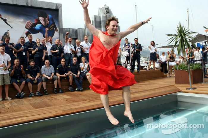 El equipo de Red Bull Racing y el director deportivo Christian Horner en una capa de Superman salta a la piscina en la cubierta de la estación de energía de Red Bull